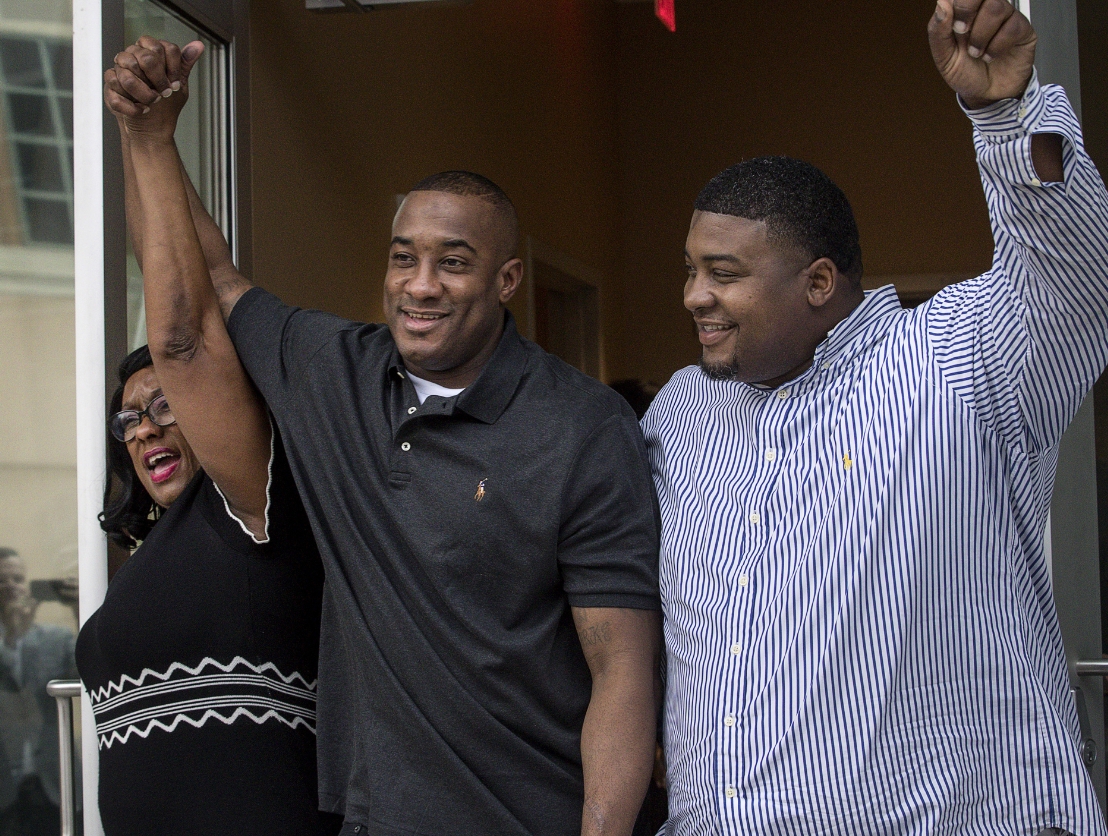 Lydell Grant holding hands with family after announcement of exoneration.
