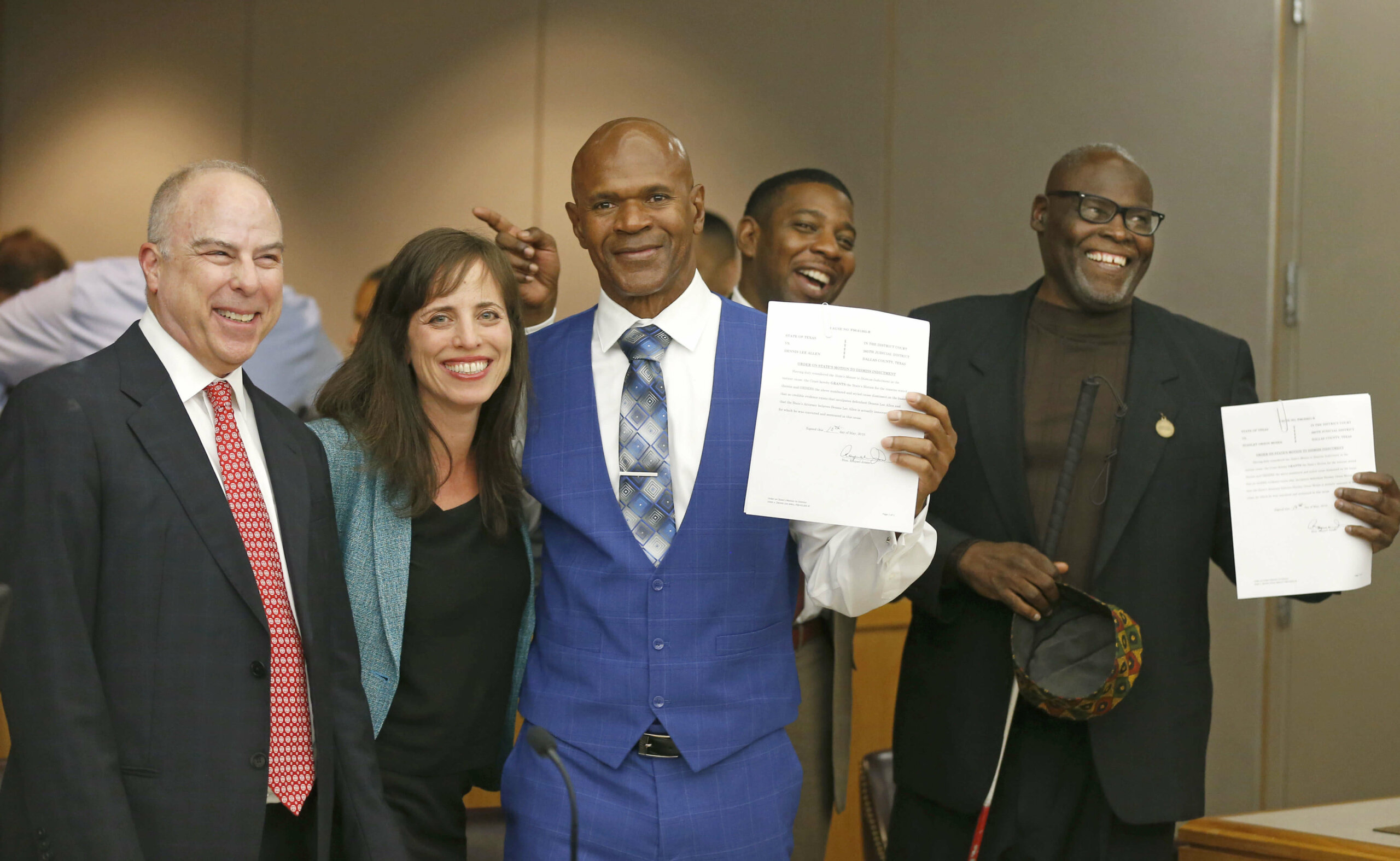 Group photo at courthouse with Dennis Lee Allen holding exoneration paperwork